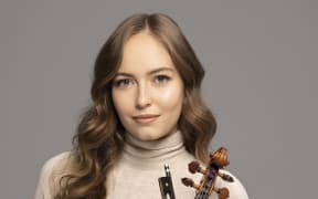 Geneva Lewis holds violin and bow