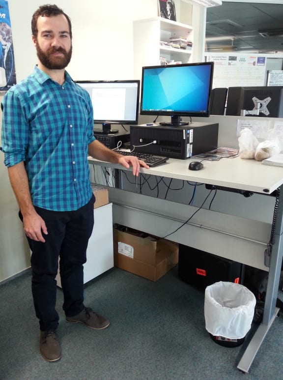 A photo of Dan Archer at a standing desk