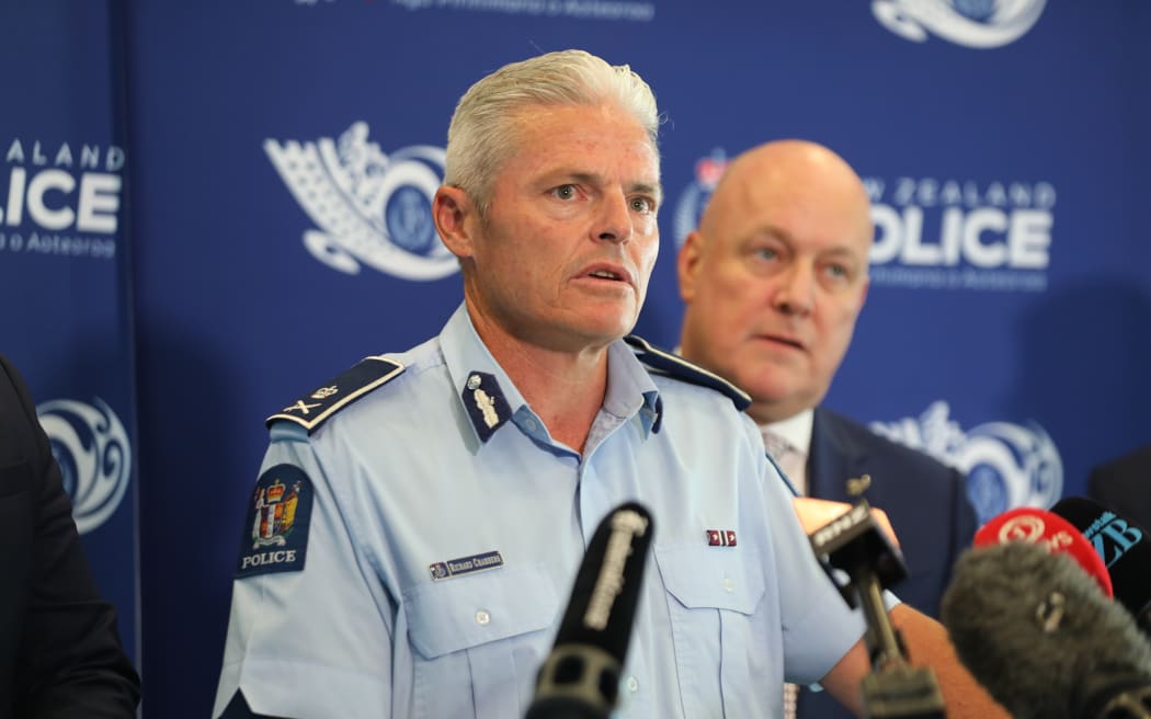 Police Commissioner Richard Chambers speaks to media while Christopher Luxon looks on behind him