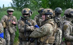 Fighters of the Russian Volunteer Corps attend a presentation for the media in northern Ukraine, not far from the Russian border, on May 24, 2023, amid Russian military invasion on Ukraine. Russian nationals fighting on Ukraine's side on May 24 hailed as a "success" a brazen mission to send groups of volunteers across the border into southern Russia and back. Russia on May 23 said it deployed jets and artillery to fight off armed attackers who crossed into the southern region of Belgorod from Ukraine, exposing weaknesses on Moscow's frontier. (Photo by SERGEY BOBOK / AFP)