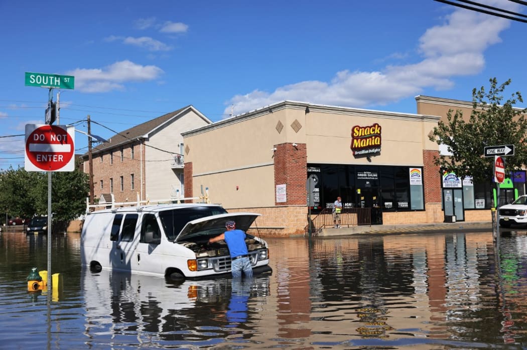 Abilio Viegas attempts to fix his flooded van on South Street on 2 September, 2021 in Newark, New Jersey.