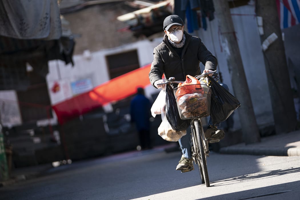 A man rides a bike in a street in Wuhan, Hubei province, 16 February 2020.