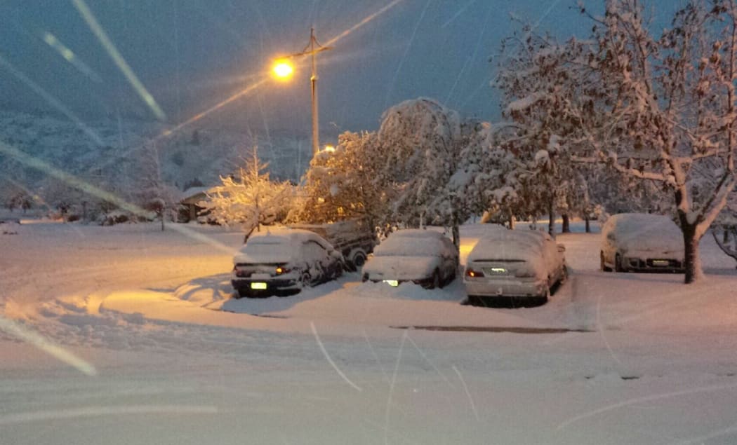 Snow-covered cars in Queenstown.