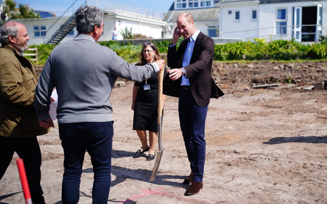 Britain's Prince William, Prince of Wales, reacts as he is handed a spade before breaking ground for the new facility to be built, during a visit to St. Mary's Community Hospital, during his visit to Hugh Town in the Isles Of Scilly, south west England on May 10, 2024. (Photo by Ben Birchall / POOL / AFP)