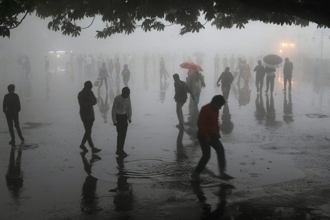 This photo taken on May 2, 2018 shows people walking under heavy rainfall in the northern hill town of Shimla in Himachal Pradesh state.