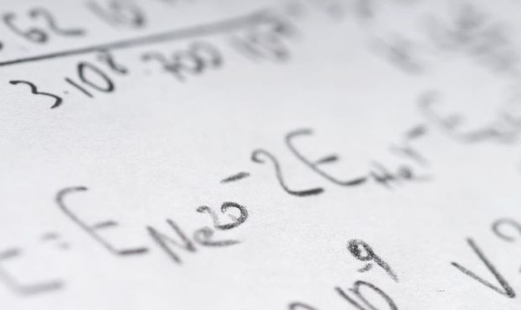 Maths book open with math problems written down