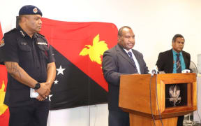 PNG prime minister James Marape (centre) announces provisions for the 14-day state of emergency beginning Tuesday 24 March, alongside police commissioner David Manning and health secretary Paison Dakulala.