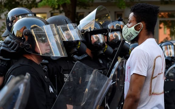 A row of police officers face off with demonstrators outside the White House to protest the death of George Floyd, who died in police custody.