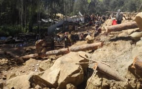 People dig through mud and rocks on 28 May, 2024, after a major landslide in Yambali village in Enga province, Papua New Guinea.