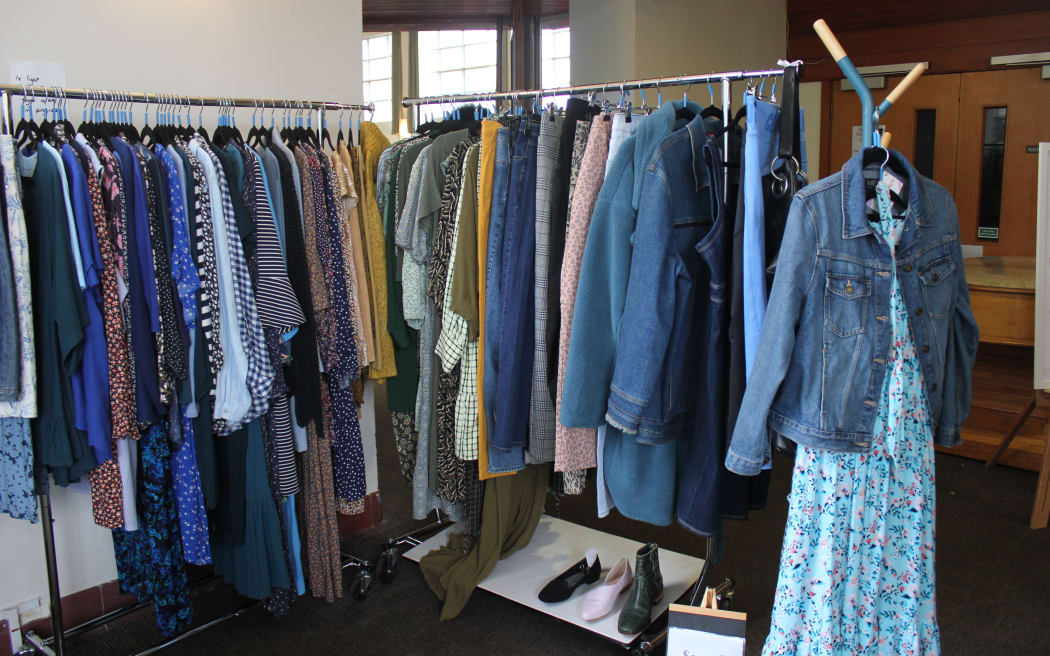 A stall with hanged clothes on rails at Gently Loved's curvy market.