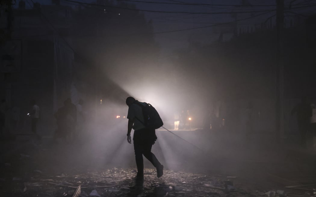EDITORS NOTE: Graphic content / A man finds his way along a debris-strewn street following Israeli air strikes in Gaza City on October 7, 2023. Palestinian militants have begun a "war" against Israel which they infiltrated by air, sea and land from the blockaded Gaza Strip, Israeli officials said, a major escalation in the Israeli-Palestinian conflict. (Photo by Mohammed ABED / AFP)