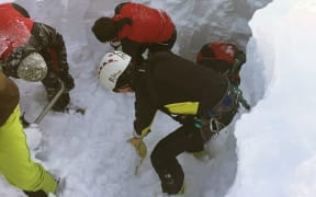 Rescuers search for a group of people buried by an avalanche in western Austria.
