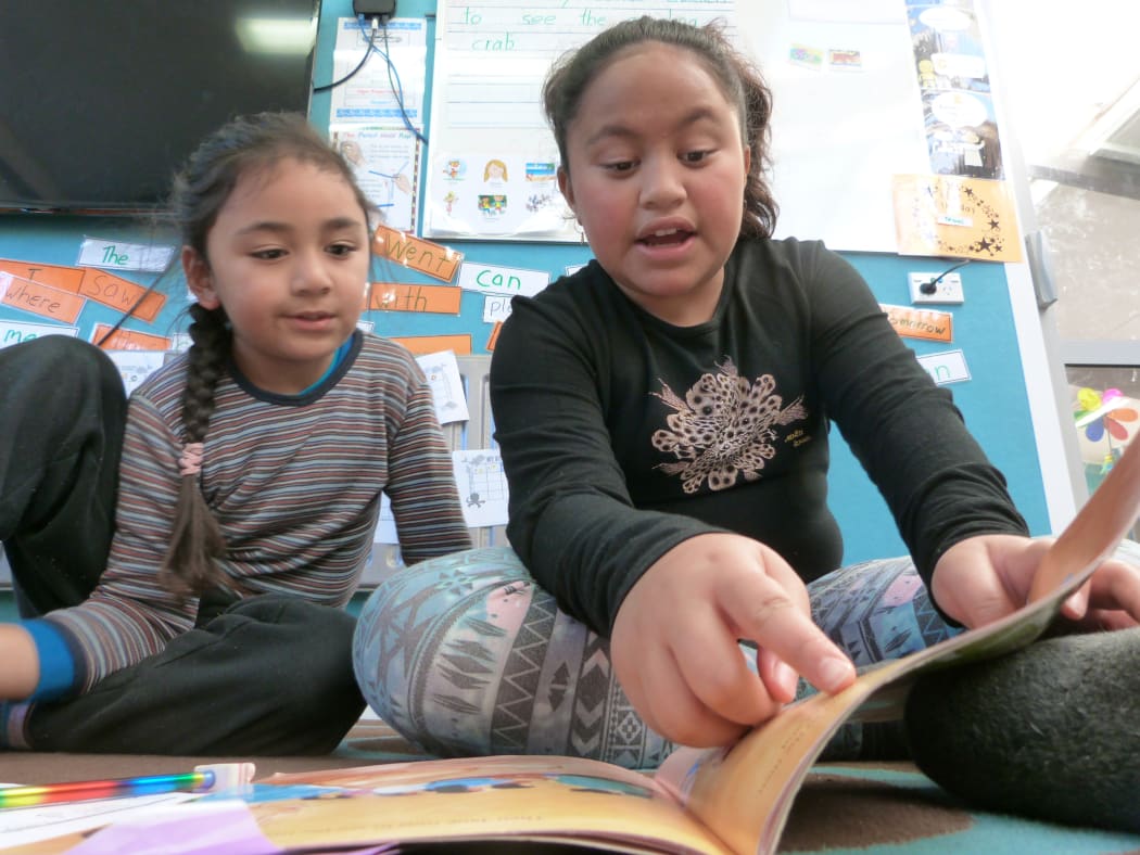 Hazel helps a younger pupil with reading. She would like to be a doctor when she's older.
