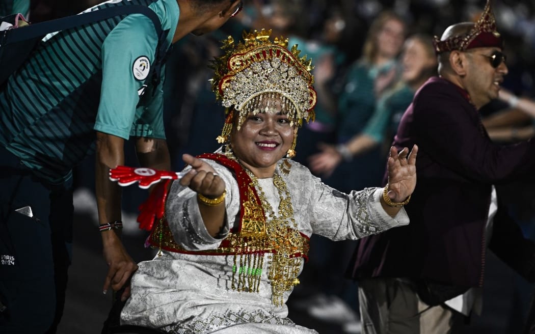 Indonesia's delegation arrives during the Parade of Nations as part of the Paris 2024 Paralympic Games Opening Ceremony at the Place de la Concorde in Paris on August 28, 2024. (Photo by JULIEN DE ROSA / POOL / AFP)