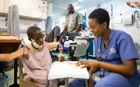 COM412 Deb Adesanya (NZL) Ward Nurse with Saidou on the ward.