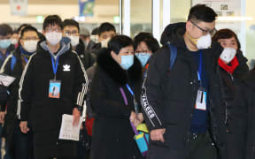 Passengers from Shanghai, wearing masks arrive at Chuo Wharf Cruise Center in Fukuoka, Fukuoka Prefecutre on January 27, 2020.