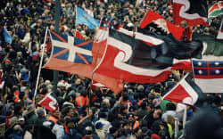A host of flags accompanied the many thousands of marchers protesting against foreshore and seabed legislation in 2004. On the right is the first New Zealand flag; also prominent is the tino rangatiratanga flag, a flag of self-determination, designed in 1989–90. Photograph by Michael Hall. Museum of New Zealand Te Papa Tongarewa, MA_E.003515. p285