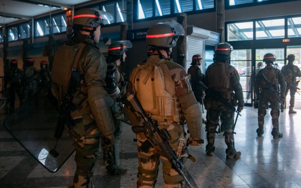 French soldiers of the 8th Marine Infantry Regiment (8e RIMa) secure the Magenta airport in Noumea, France's Pacific territory of New Caledonia, on May 17, 2024. France deployed troops to New Caledonia's ports and international airport, banned TikTok and imposed a state of emergency on May 16 after three nights of clashes that have left four dead and hundreds wounded. Pro-independence, largely indigenous protests against a French plan to impose new voting rules on its Pacific archipelago have spiralled into the deadliest violence since the 1980s, with a police officer among several killed by gunfire. (Photo by Delphine Mayeur / AFP)