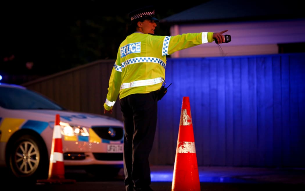 A police officer directing traffic at an alcohol check point.