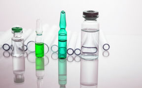 Group of vials with medication on blue methacrylate table. Horizontal composition.