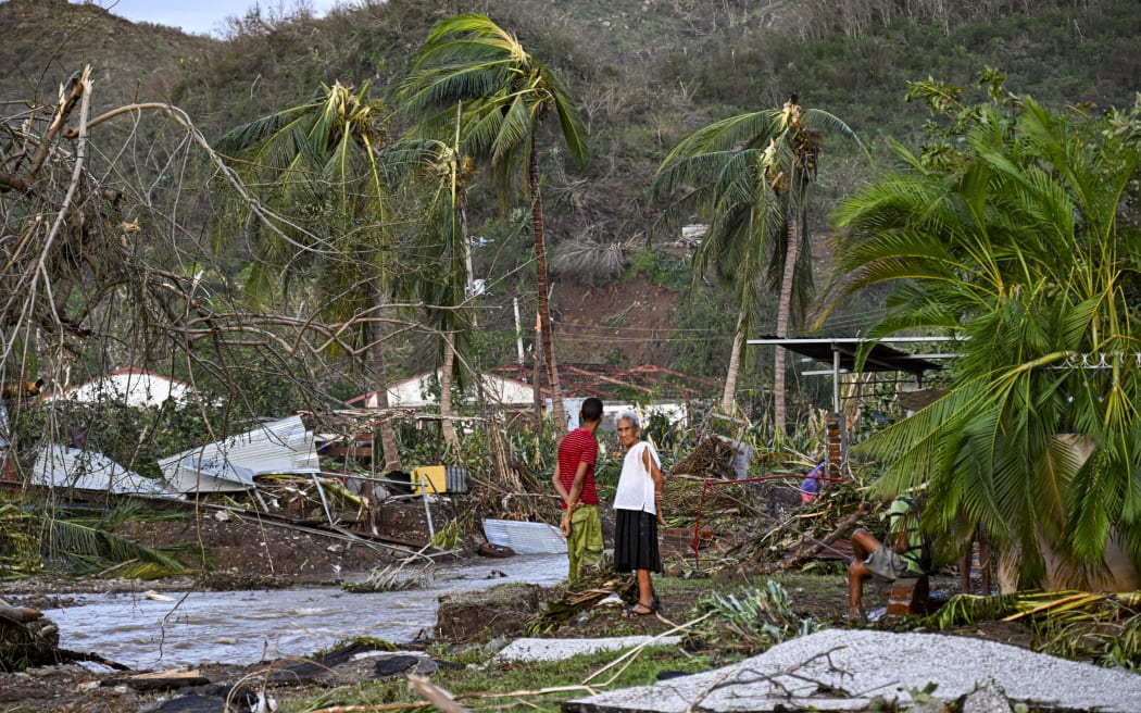 A family from the town of El Cobre, in the province of Santiago de Cuba, remain in their destroyed house after the passage of Hurricane Melissa, on October 29, 2025.