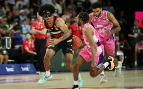 Keanu Pinder of the Perth Wildcats is challenged by Parker Jackson-Cartwright of the Breakers during their NBL game in Auckland.