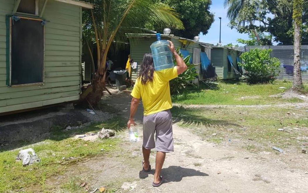 A refugee carries well water in the Manus Island detention centre.