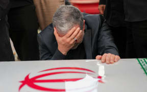 This handout picture provided by the Iranian foreign ministry shows Iran's Foreign Minister Abbas Araghchi mourning next to the coffin of Iranian Revolutionary Guards commander Hossein Salami, who was killed during Israeli strikes on the first day of the war, during a state funeral procession at Enghelab (Revolution) Square in the capital Tehran on June 28, 2025. Iran began a state funeral service on June 28 for around 60 people, including its military commanders, killed in its war with Israel, after Tehran's top diplomat condemned  Donald Trump's comments on supreme leader Ali Khamenei as "unacceptable". (Photo by Iranian Foreign Ministry / AFP) / === RESTRICTED TO EDITORIAL USE - MANDATORY CREDIT "AFP PHOTO / HO / IRANIAN FOREIGN MINISTRY" - NO MARKETING NO ADVERTISING CAMPAIGNS - DISTRIBUTED AS A SERVICE TO CLIENTS ===