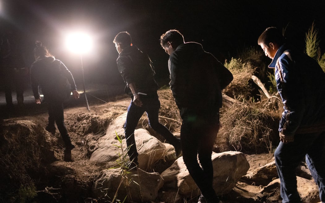 Unaccompanied minors walk up bank of the Rio Grande after crossing the US-Mexico border early on April 30, 2021 in Roma, Texas.