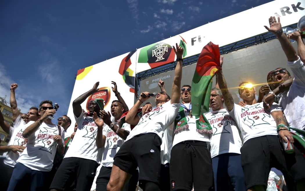 Portugal captain Cristiano Ronaldo and his team-mates on stage at Alameda square in Lisbon on July 11, 2016 where thousands of supporters welcome them with scarfs and flags to celebrate their victory over France in their Euro 2016 final