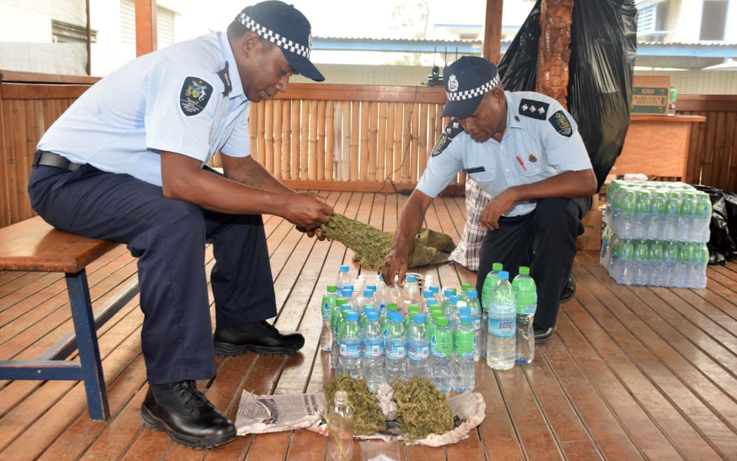 Solomons police officers with confiscated kwaso and marijuana.