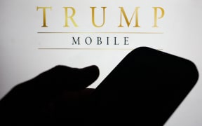Trump Mobile website displayed on a laptop screen and Trump Mobile logo displayed on a phone screen are seen in this illustration photo taken in Krakow, Poland on June 16, 2025. (Photo by Jakub Porzycki/NurPhoto) (Photo by Jakub Porzycki / NurPhoto via AFP)