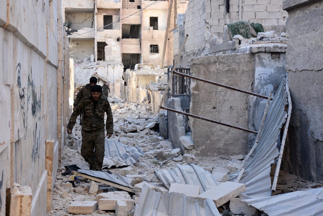 Syrian pro-government forces inspect an area in the Masaken Hanano district in eastern Aleppo, a day after they resized it from rebel fighters.