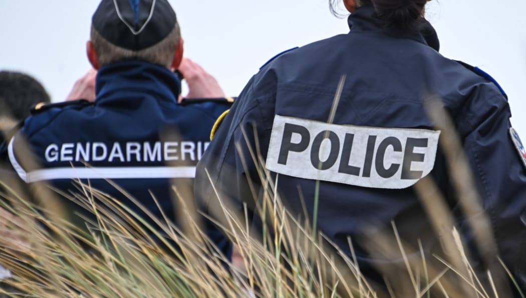 A French gendarme and police officer observe the beach of Oye-Plage, near Calais, northern France, as part of a monitoring mission of beaches from which migrants attempt to cross the English Channel to reach the United Kingdom, on Brexit Day, January 31, 2020.