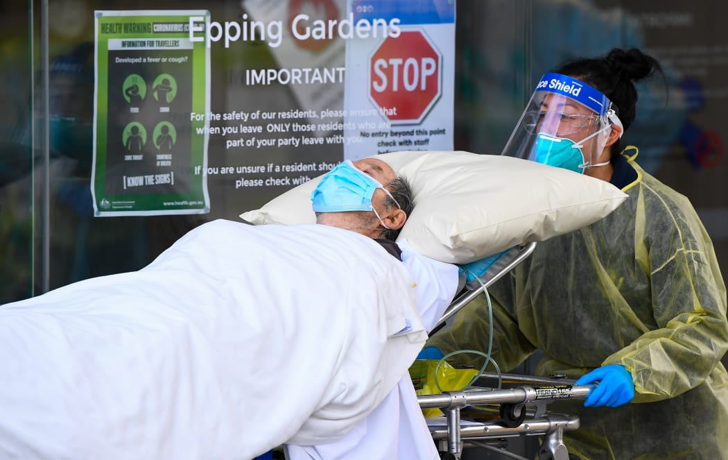 Ambulance officers transfer a resident from the Epping  Gardens aged care facility in the Melbourne suburb of Epping on 28 July 2020.