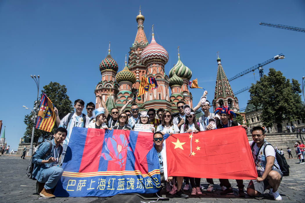 Chinese football fans of Lionel Messi, Argentina, holding flags of FC Barcelona and China, pose for photos in front of Saint Basil's Cathedral as they visit the city during the 2018 FIFA World Cup in Moscow, Russia, 17 June.
