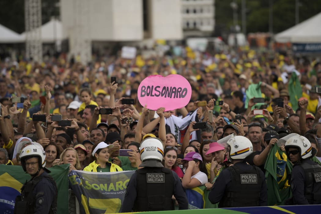 Supporters of Brazil's President-elect Jair Bolsonaro watch as the presidential convoy heads to the National Congress for his swearing-in ceremony in Brasilia.