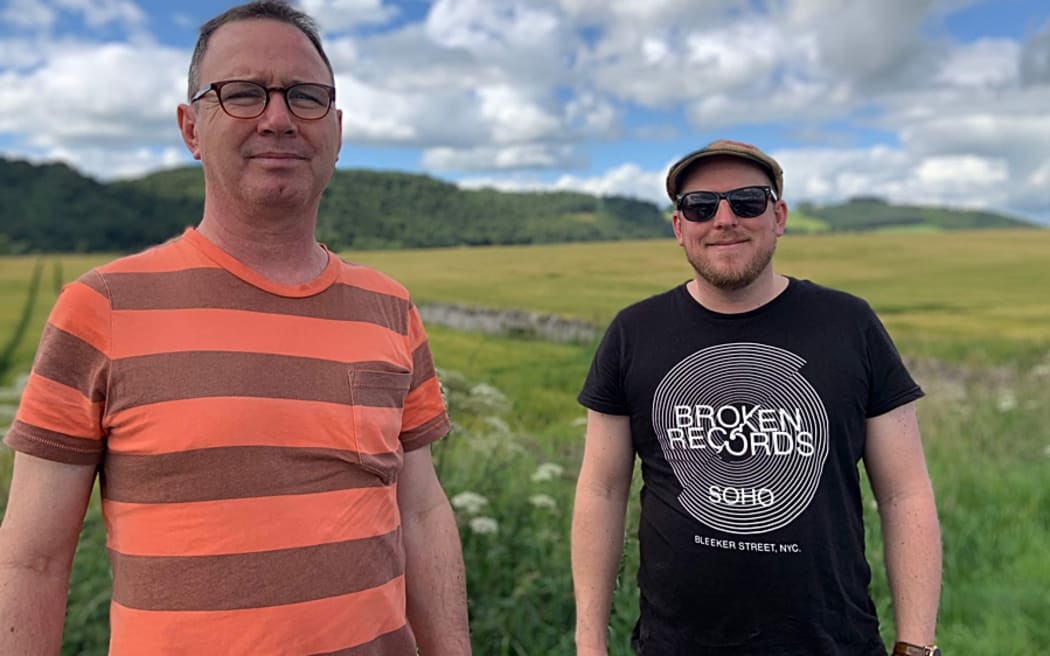 John Rae and Ben Wilcock standing in a field, looking at the camera.