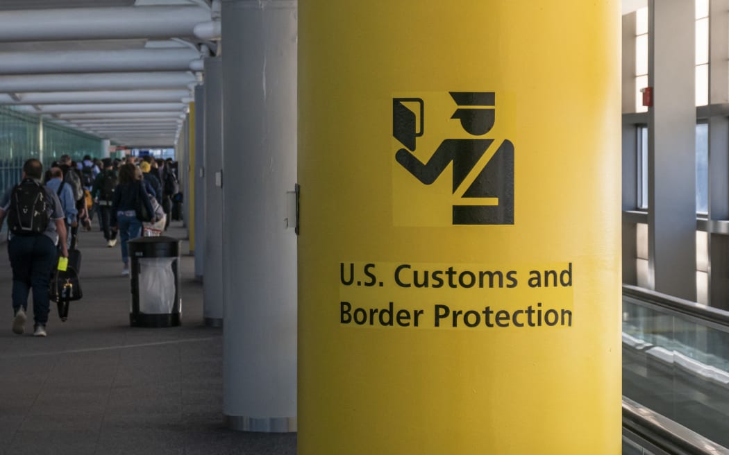 U.S. Customs and Border Protection CBP sign, inscription and symbol in yellow background in Newark Liberty International Airport EWR serving the New York Metropolitan area with arriving passenger walking in the terminal towards the immigration passport control. United States Customs and Border Protection is the largest federal law enforcement agency of the United States Department of Homeland Security with agents and officers, it's the primary border control organization. Newark, United States of America on November 2024 (Photo by Nicolas Economou/NurPhoto) (Photo by Nicolas Economou / NurPhoto via AFP)
