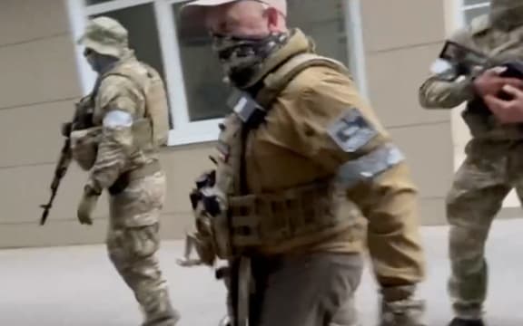 This video grab taken from handout footage posted on June 24, 2023 on the Telegram channel @razgruzka_vagnera shows Yevgeny Prigozhin (C) walking in the city of Rostov-on-Don.