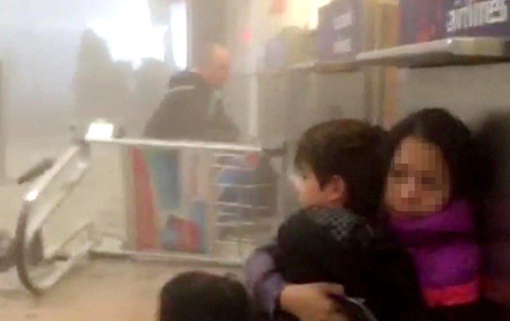A screengrab from a video by RTL TVI showing people taking cover after a blast inside Zavente airport.
