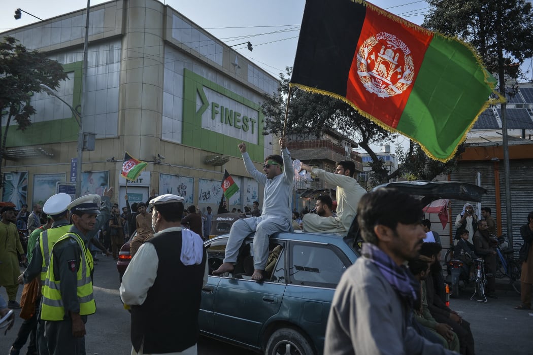 People carry Afghanistan's national flag on the occasion of 102th Independence Day of the country, Kabul, 19 August  2021,  amid the Taliban's military takeover of Afghanistan.
