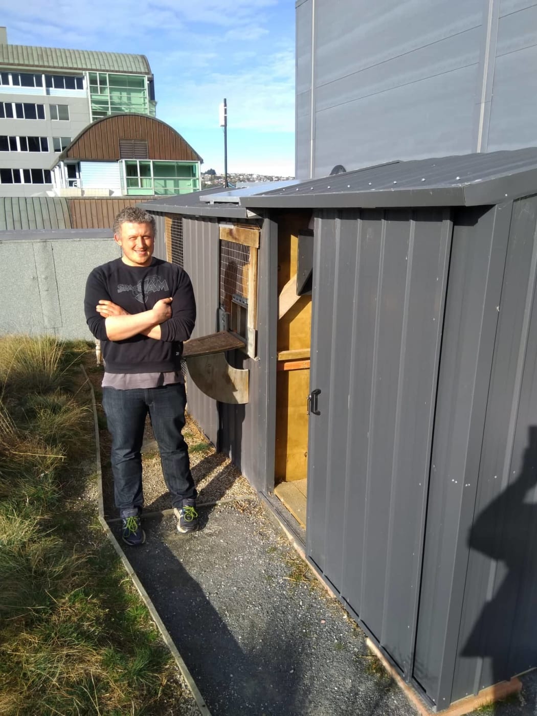 Dr. Damien Scarf, psychology lecturer at Otago University outside his pigeon loft.