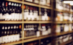 Blurred photo of wine bottles on shelves