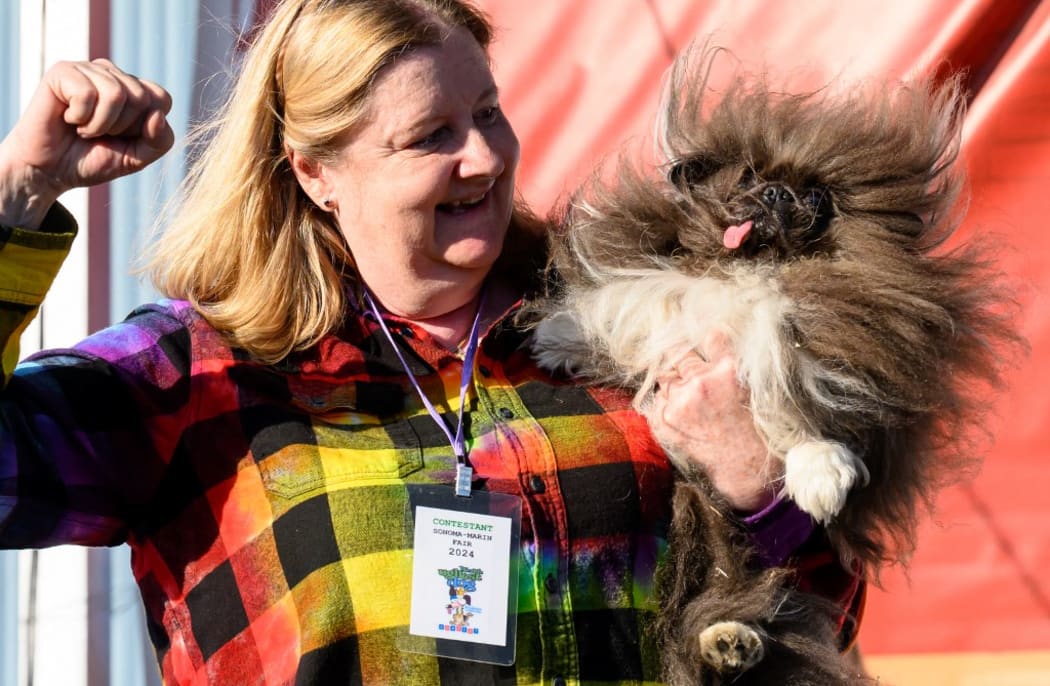 Owner Ann Lewis holds up her dog Wild Thang after winning first prize in the annual World's Ugliest Dog contest at the Sonoma-Marin Fair in Petaluma, California, on June 21, 2024. Wild Thang, a Pekingese dog who had already entered the competition four times, finally won the 34th annual World's Ugliest Dog competition and was awarded $5,000. (Photo by JOSH EDELSON / AFP)