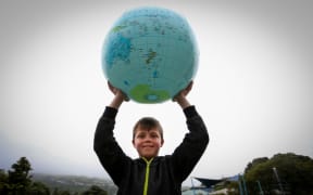 9 year old Brodie Murdoch from Hamption Hill Primary School holds up the world.