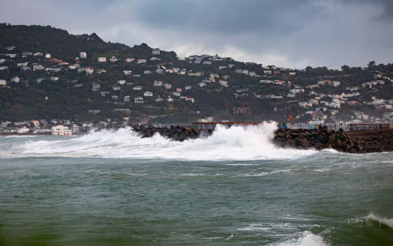 Waves crash against a sea wall near the end of Wellington Airport