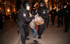 Police officers detain a person during a protest against Russia's invasion of Ukraine in central Moscow on March 3, 2022.