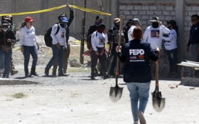 A member of the Special Prosecutor's Office for Missing Persons carries shovels, while members of the collective Guerreros Buscadores - Warrior Searchers visit the Izaguirre ranch, where on 5 March, they located three human crematory ovens while searching for their missing relatives, in a rural area of the western Mexican state of Jalisco, local authorities said on 12 March, 2025.