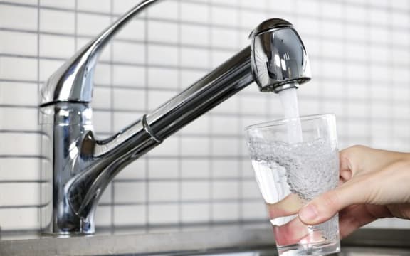 water running from a tap into a glass